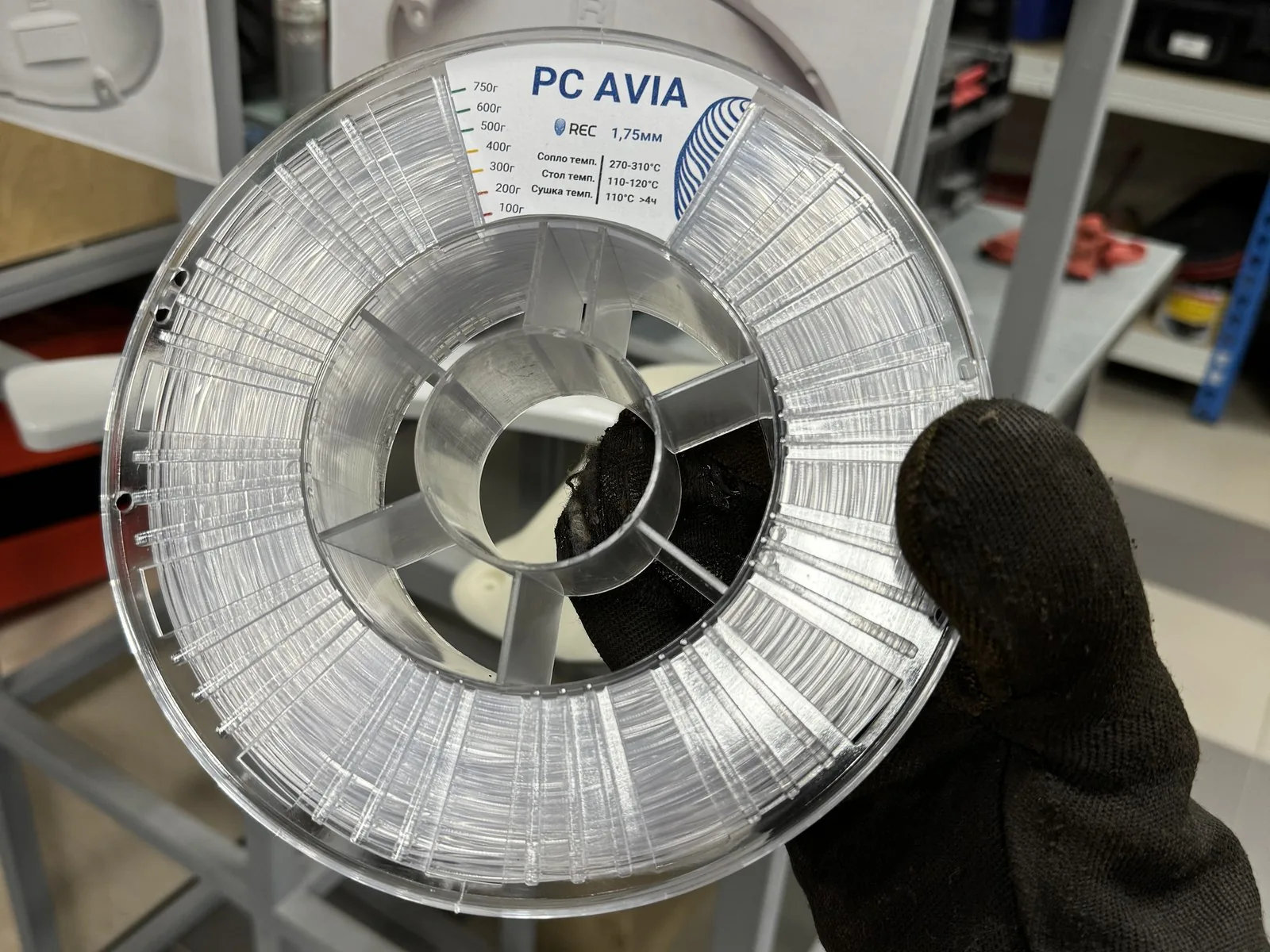 Катушка авиационного поликарбоната PC AVIA в руке в защитной перчатке
